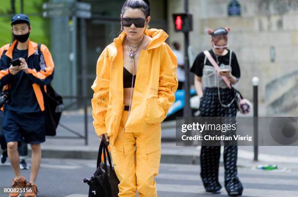 Guest wearing yellow zip hoody, cropped top, yellow pants outside Y-3 during Paris Fashion Week Menswear Spring/Summer 2018 Day Five on June 25, 2017...