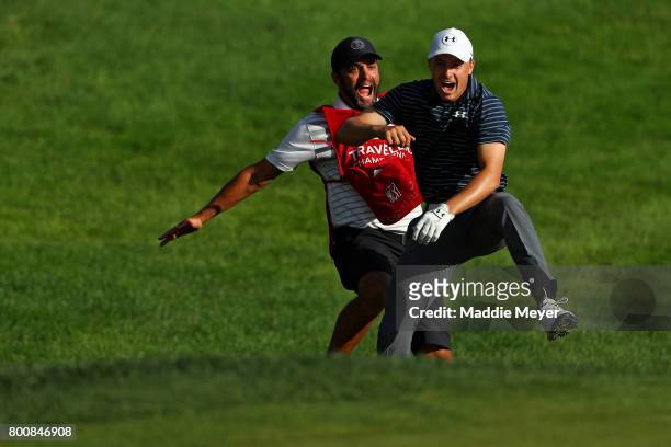 Jordan Spieth of the United States celebrates with caddie Michael Greller after chipping in for birdie from a bunker on the 18th green to win the...