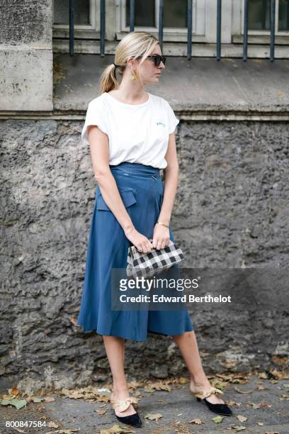 Camille Charriere wears sunglasses, a white t-shirt, a blue skirt, a vichy gingham bag, black shoes, outside the Paul Smith show, during Paris...