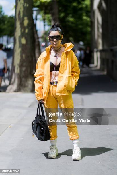 Guest wearing yellow zip hoody, cropped top, yellow pants outside Y-3 during Paris Fashion Week Menswear Spring/Summer 2018 Day Five on June 25, 2017...