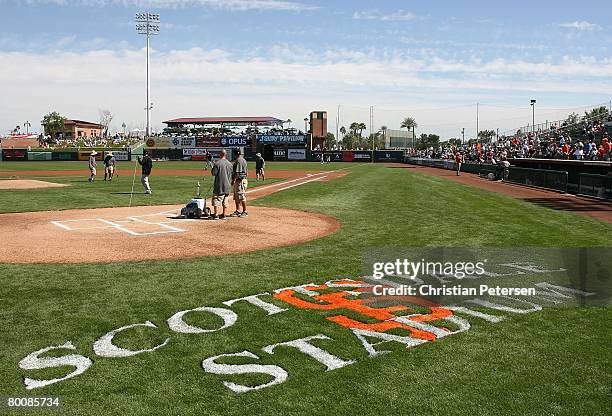 The grounds crew prepare the field at Scottsdale Stadium before the spring training game between the San Francisco Giants and the Oakland Athletics...