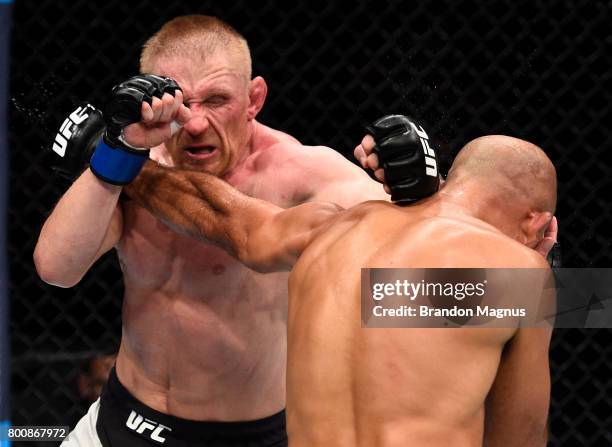 Dennis Siver of Germany and BJ Penn trade punches in their featherweight bout during the UFC Fight Night event at the Chesapeake Energy Arena on June...