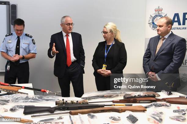 Prime Minister Malcolm Turnbull looks at a collection of contraband weapons seized by the AFP at AFP Headquarters on June 26, 2017 in Melbourne,...