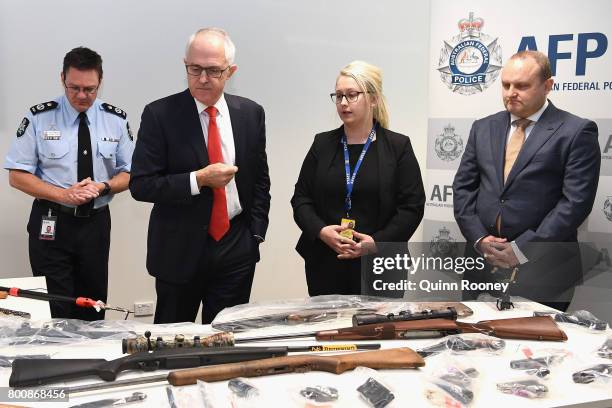 Prime Minister Malcolm Turnbull looks at a collection of contraband weapons seized by the AFP at AFP Headquarters on June 26, 2017 in Melbourne,...