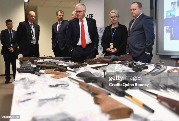 Prime Minister Malcolm Turnbull looks at a collection of contraband weapons seized by the AFP at AFP Headquarters on June 26, 2017 in Melbourne,...