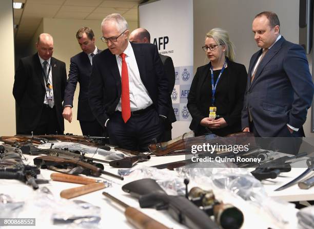 Prime Minister Malcolm Turnbull looks at a collection of contraband weapons seized by the AFP at AFP Headquarters on June 26, 2017 in Melbourne,...