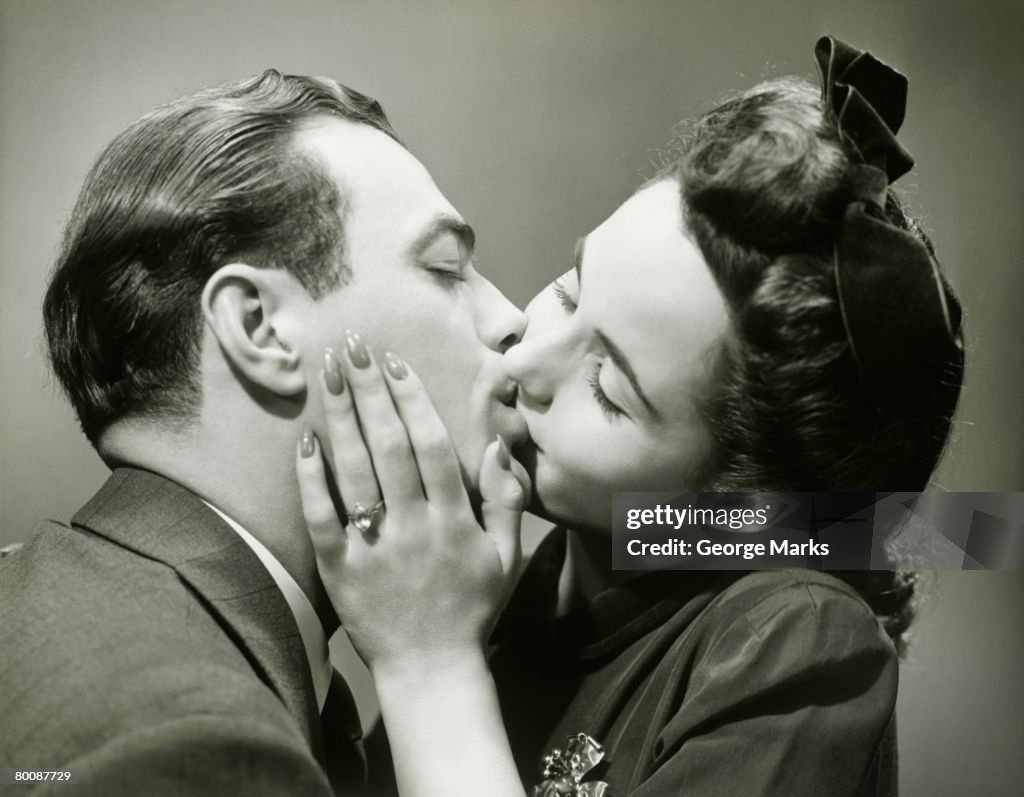 Young couple kissing, close-up, studio shot