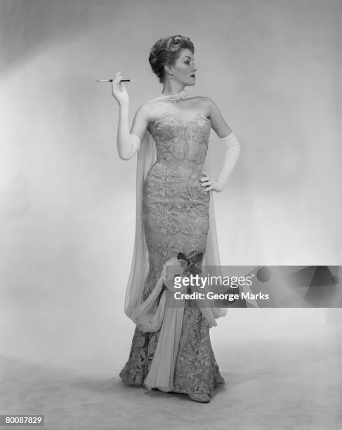 woman wearing evening dress, holding cigarette, studio shot - strapless foto e immagini stock