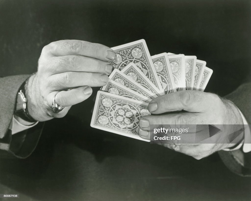 Man holding playing cards, close up of hands