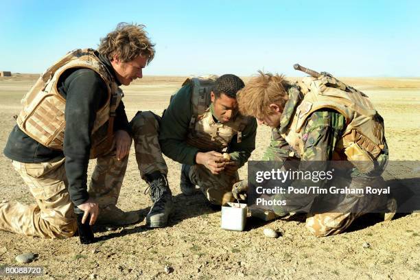 Prince Harry prepares a breakfast of biscuits mixed with jam and butter with Trooper 'Max' Loloma and Lance Cpl Steve 'Geri' Halliwell in the desert...