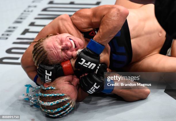 Felice Herrig attempts to secure a rear choke submission against Justine Kish in their women's strawweight bout during the UFC Fight Night event at...