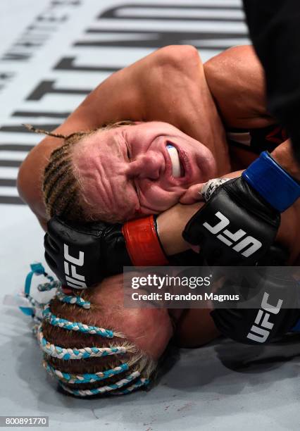 Felice Herrig attempts to secure a rear choke submission against Justine Kish in their women's strawweight bout during the UFC Fight Night event at...