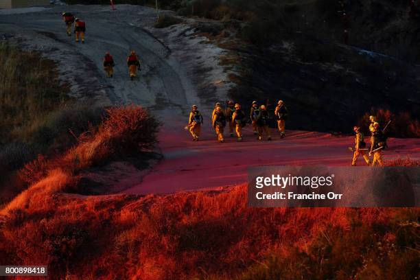 Firefighter walk down a hill in Santa Clarita, Ca June 25,2017. Firefighters battling a fast-moving brush fire in the Santa Clarita area that burned...