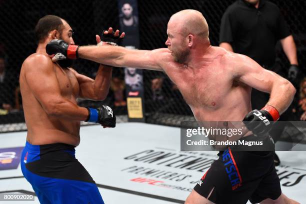 Tim Boetsch punches Johny Hendricks in their middleweight bout during the UFC Fight Night event at the Chesapeake Energy Arena on June 25, 2017 in...