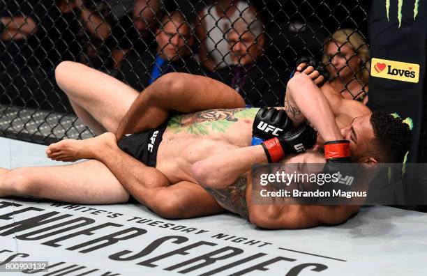 Kevin Lee attempts to secure a rear choke submission against Michael Chiesa in their lightweight bout during the UFC Fight Night event at the...