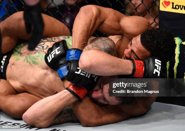 Kevin Lee attempts to secure a rear choke submission against Michael Chiesa in their lightweight bout during the UFC Fight Night event at the...