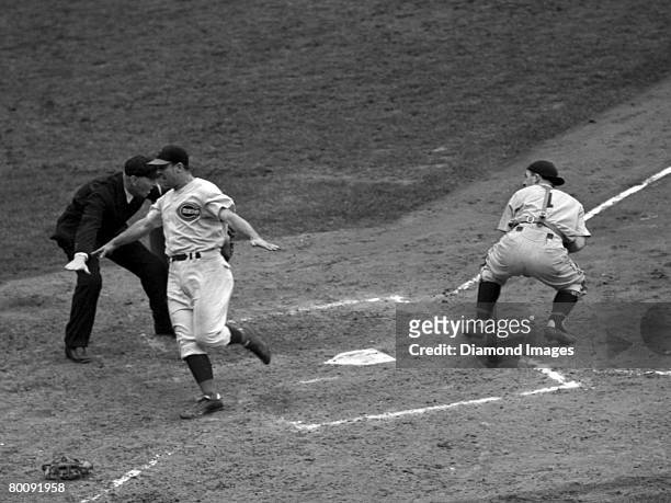 Catcher Jimmie Wilson of the Cincinnati Reds is safe at home ahead of the throw from third baseman Mike "Pinky" Higgins to catcher George "Birdie"...