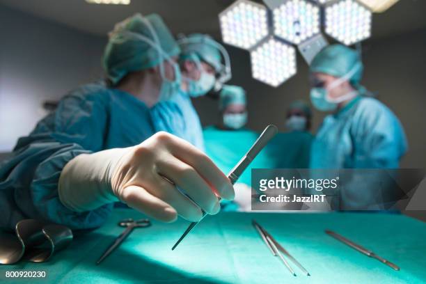 cirurgiões em equipamento cirúrgico completo durante a operação - surgery - fotografias e filmes do acervo