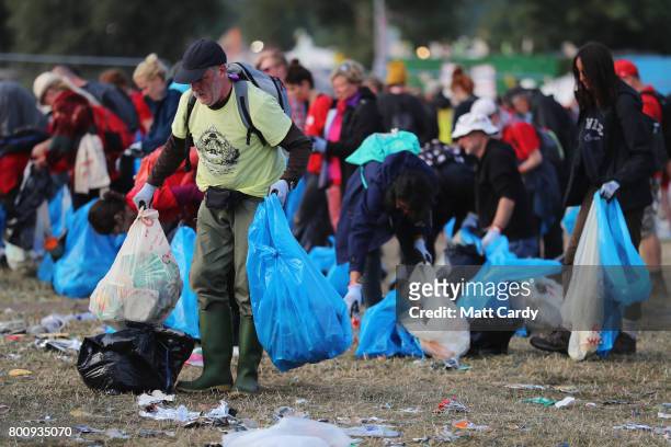Litter pickers begin the job of clearing the fields at the Glastonbury Festival site at Worthy Farm in Pilton on June 26, 2017 near Glastonbury,...