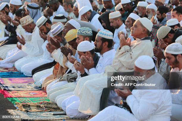 Muslims offer prayers during Eid al-Fitr at the velodrome de Champ-Fleuri in Saint-Denis de la Reunion on the French Indian Ocean island of Reunion...