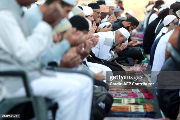 Muslims offer prayers during Eid al-Fitr at the velodrome de Champ-Fleuri in Saint-Denis de la Reunion on the French Indian Ocean island of Reunion...