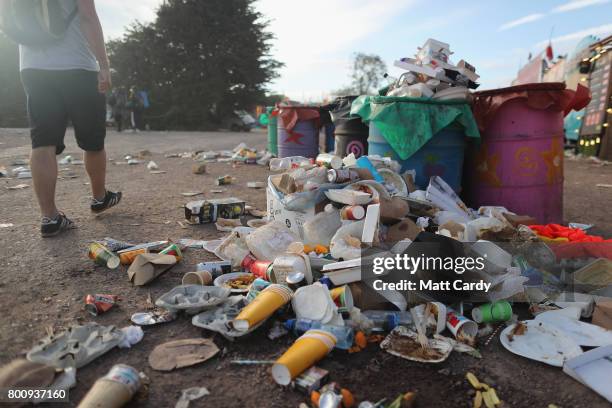 Festival goer walks next to litter bins as the clear up begins at the Glastonbury Festival site at Worthy Farm in Pilton on June 26, 2017 near...