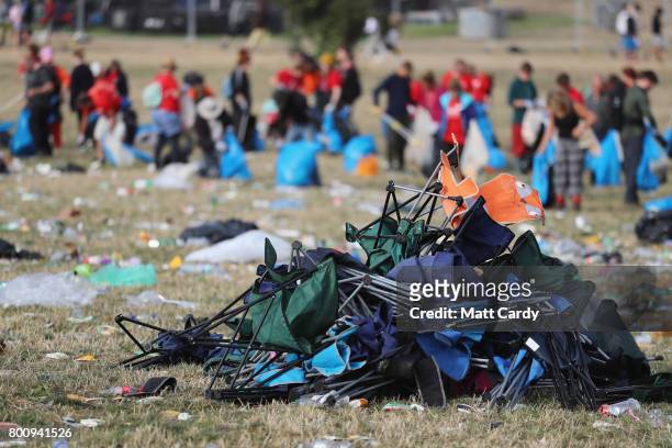 Discarded foldable camping chairs lie in a field as litter pickers begin the job of clearing the Glastonbury Festival site at Worthy Farm in Pilton...