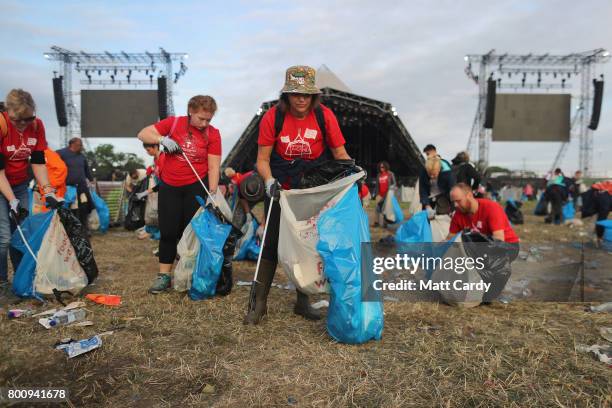 Litter pickers begin the job of clearing the fields at the Glastonbury Festival site at Worthy Farm in Pilton on June 26, 2017 near Glastonbury,...