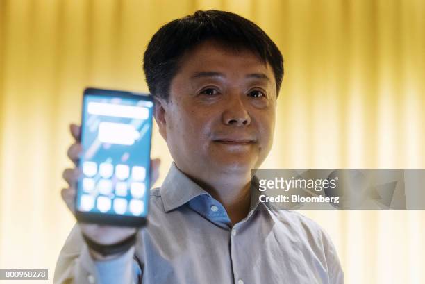 Wang Xiang, vice president of global operations at Xiaomi Corp., holds a Mi Max 2 smartphone for a photograph during a news conference in Hong Kong,...
