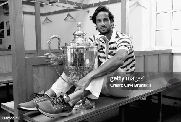 Feliciano Lopez of Spain poses with the trophy in the locker room after winning the mens singles final against Marin Cilic of Croati during day seven...