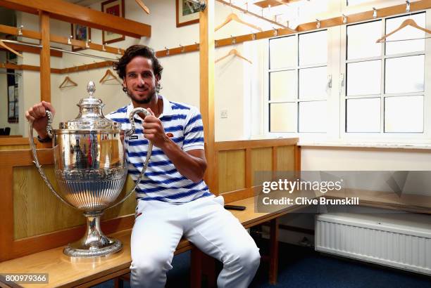 Feliciano Lopez of Spain poses with the trophy in the locker room after winning the mens singles final against Marin Cilic of Croati during day seven...