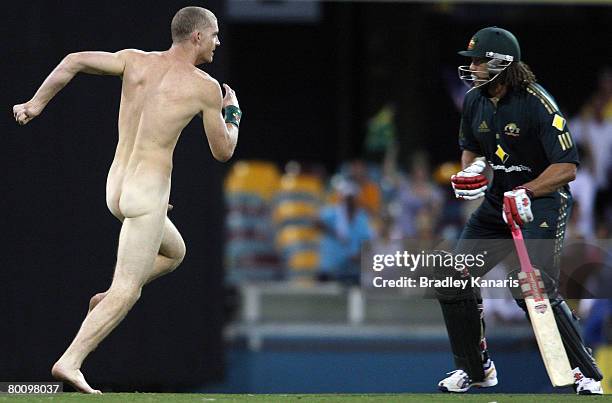 Andrew Symonds of Australia lines up a shoulder charge on a streaker who invaded the pitch during the Commonwealth Bank Series One Day International...