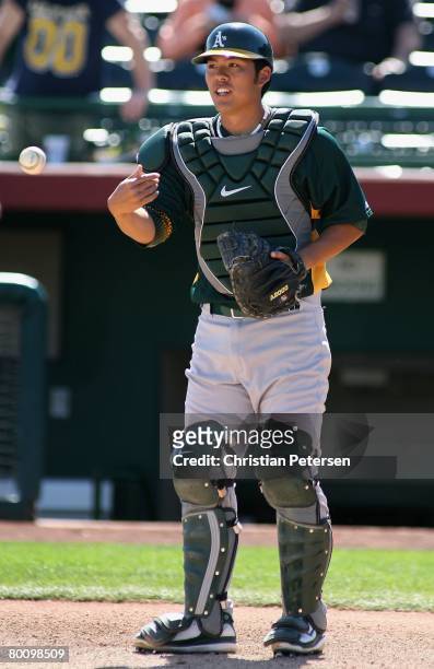 Catcher Kurt Suzuki of the Oakland Athletics warms up before the spring training game against the San Francisco Giants at Scottsdale Stadium on March...