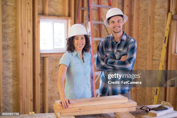 weibliche arbeitnehmer baupläne heraus die nächste phase des bauvorhabens auf einem klemmbrett - wohncontainer stock-fotos und bilder