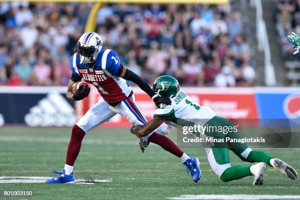 Defensive back Jovon Johnson of the Saskatchewan Roughriders grabs a hold of wide receiver Tiquan Underwood of the Montreal Alouettes during the CFL...