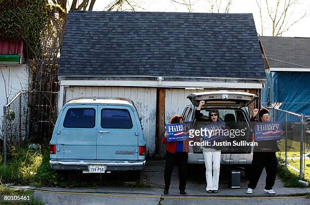 Supporters of Democratic presidential hopeful U.S. Sen. Hillary Clinton carry signs as they dance outside of a polling station at the J.P. Henderson...