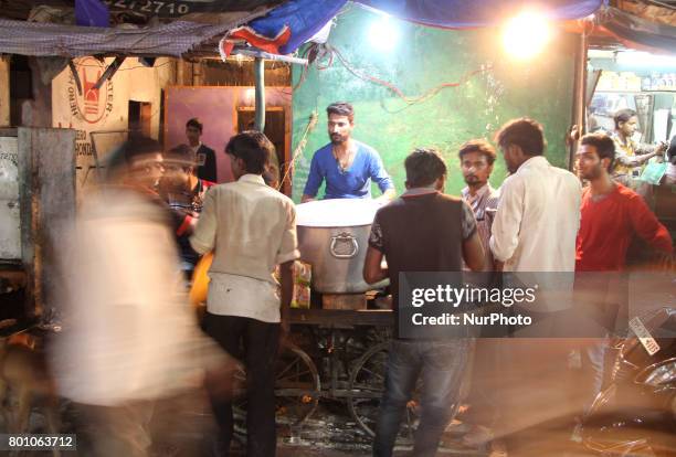 Indian people gather near a roadside traditional biriyani shop , on the eve of Eid al-Fitr festival , in Allahabad on June 25,2017.