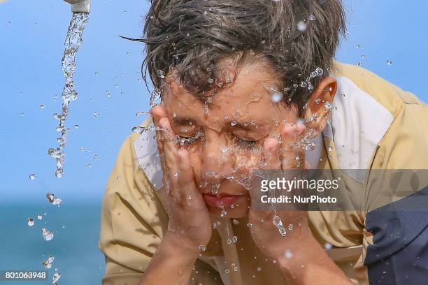 Sri Lankan Muslim boy washes his face before attending prayers during an event to celebrate Eid al-Fitr to mark the end of the holy fasting month of...