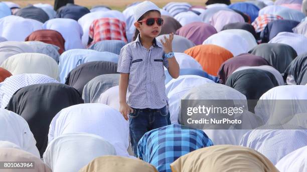 Sri Lankan Muslim boy stands out while adult men attends the Eid al-Fitr prayers to mark the end of the holy fasting month of Ramadan in Colombo, Sri...