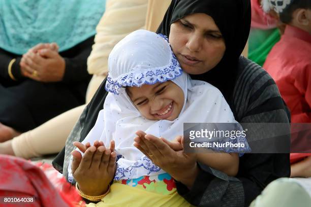 Sri Lankan Muslim woman shares a light moment with her child while attending the Eid al-Fitr prayers to mark the end of the holy fasting month of...