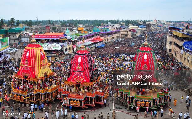 This photo taken on June 25, 2017 shows Indian Hindu devotees by huge chariots representing Lord Jagannath, Brother Balabhadra and Devi Subhadras in...