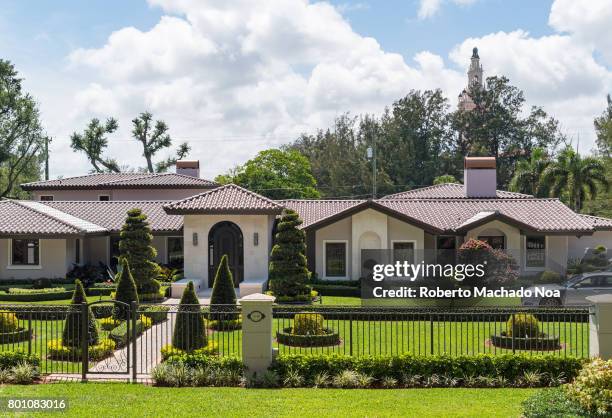 Luxurious Coral Gables houses. Facade of a lavish modern house with slant roofs and beautifully manicured lawns.