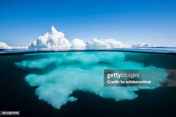 above the surface and below the surface view of ice formations at the ice floe edge on a bright sunny day, northern baffin island, canada. - baffinland stock-fotos und bilder