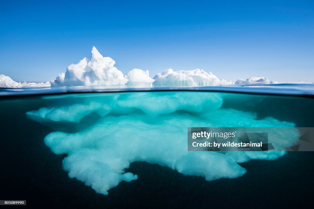 Above the surface and below the surface view of ice formations at the ice floe edge on a bright sunny day, northern Baffin Island, Canada.