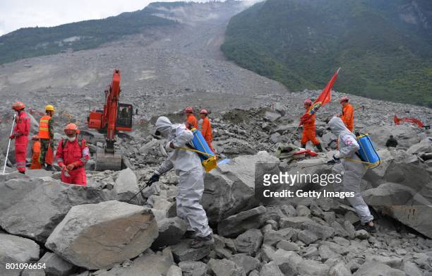 Rescuers search for survivors at the accident site after a landslide at Xinmo village on June 26, 2017 in Maoxian County, China. The landslide...