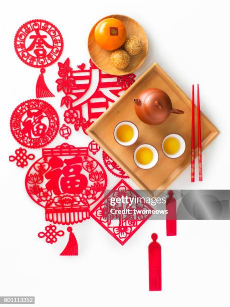 flat lay chinese new year snack and hot tea on traditional paper cutting background. - lunar new year cup 2017 stock-fotos und bilder