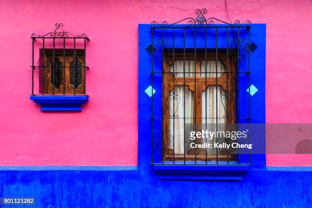 pink and blue wall with window - san cristobal stock-fotos und bilder