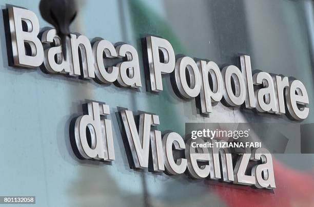 An Italian national flag reflects on the window of the Banca Popolare di Vicenza branch at Piazza Venezia in central Rome on June 26, 2017. Up to...