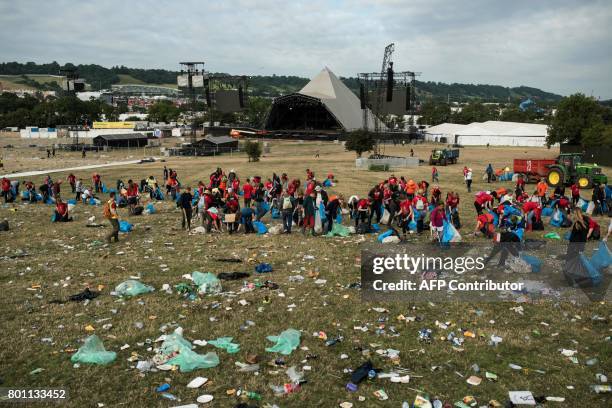 Litter-picking staff collect discarded rubbish from the area in front of the Pyramid Stage at the end of the Glastonbury Festival of Music and...