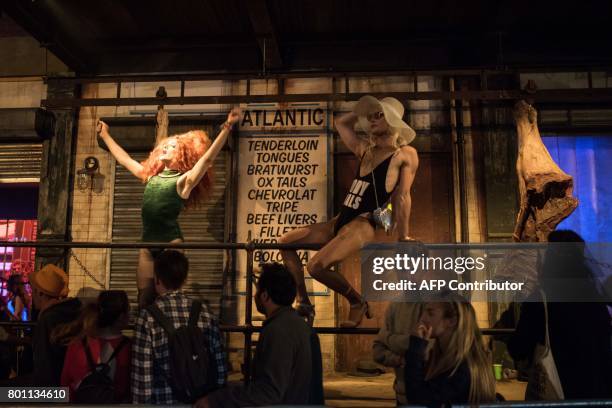 Performers entertain festival-goers queueing to enter a nightclub in the Block9 area of the Glastonbury Festival of Music and Performing Arts on...